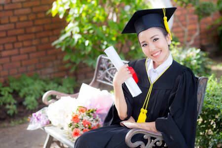 Happy graduated student girl hold certificate - congratulations of education success.の写真素材