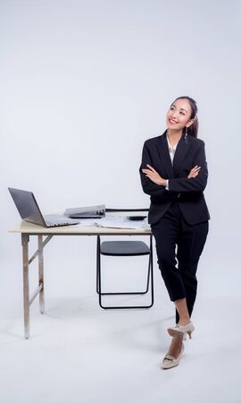 Confident businesswoman in office smiling at the camera with folded arms in office.の写真素材