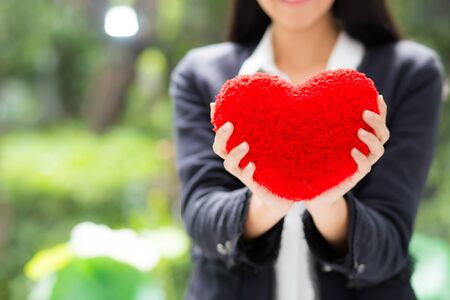 Red heart in businesswoman hand - Asian woman with hope concept.の写真素材