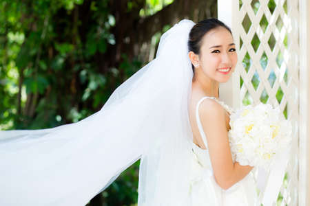beautiful young woman on wedding day in white dress in the garden. Female portrait in the park.の写真素材