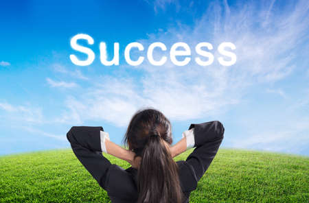 Man looking text success on green meadow on blue clear sky backgroundの写真素材