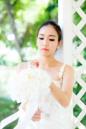 beautiful young woman on wedding day in white dress in the garden. Female portrait in the park - Selective focus.の写真素材