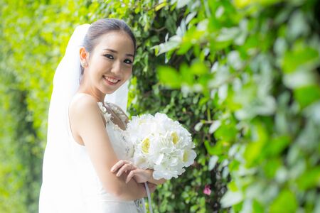 beautiful young woman on wedding day in white dress in the tree wall. Female portrait in the park - Selective focusの写真素材