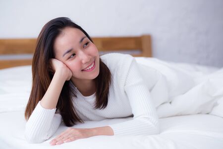 woman beautiful smiling woman portrait wake up early morning after sleeping and lying in bed.の写真素材