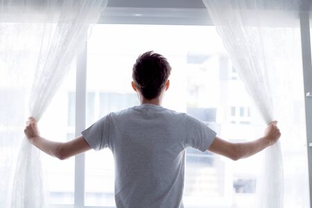 man and hope concept - man opening window curtains business concept.の写真素材