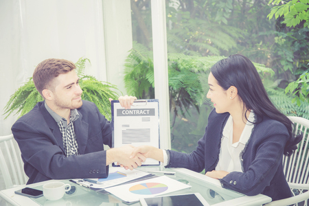 Business man and woman meeting and showing success with handshake in the office, agreement of partnership employee with together, communication concept.の写真素材