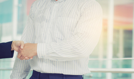 Handshake of agree with businessman and businesswoman after successful business meeting with partnership.の写真素材