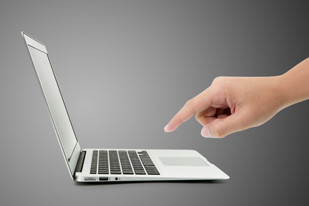 Man typing on notebook with something, hand push digital data with computer network on grey background, business technology concept.の写真素材