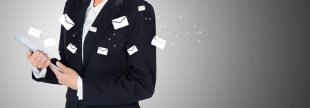 Hand holding woman check and sending message with email in a phone on grey background, banner communication concept.の写真素材