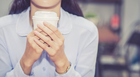 Closeup young asian woman drinking coffee and smile in the morning at cafe, girl sitting in coffee shop for breakfast and leisure during free time.の写真素材