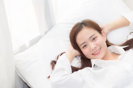 Beautiful asian young woman sleeping lying in bed with head on pillow comfortable and happy. girl with relax for health concept.の写真素材