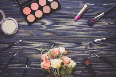 Top view a collection of cosmetic makeup and flower on wooden table background, products cosmetic fashion concept, vintage retro style.の写真素材