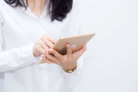Closeup woman using tablet computer in the cement background, businesswoman looking tablet, communication concept.の写真素材
