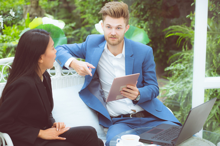 Businesspeople using digital tablet computer working in modern office, business two people talking planning teamwork with labtop, partner man and woman group team with discussion.の写真素材