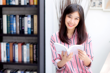 Beautiful of portrait young asian woman relax sitting reading book in living room at home, girl study literature, education and llifestyle concept.の写真素材