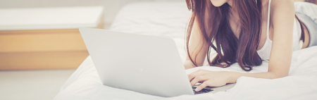 Banner website beautiful asian young woman relax listening to music with headphone and laptop online internet on vacation in bedroom, cheerful of asia girl leisure, lifestyle concept.の写真素材