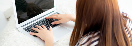 Banner website asian young woman lying on bed using laptop at bedroom for leisure and relax, freelance with girl working notebook, communication concept, top view.の写真素材