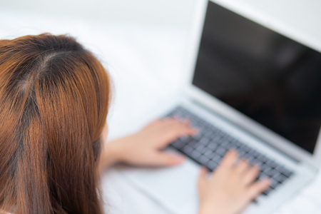 Closeup young asian woman using laptop for leisure on bedroom, girl working online with notebook freelance, business concept, top view.の写真素材