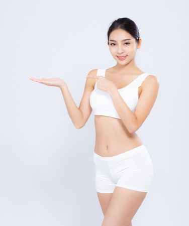 Portrait young asian woman smiling beautiful body diet with fit presenting something copy space on the hand isolated on white background, model girl weight slim with cellulite or calories, health and wellness concept.の写真素材