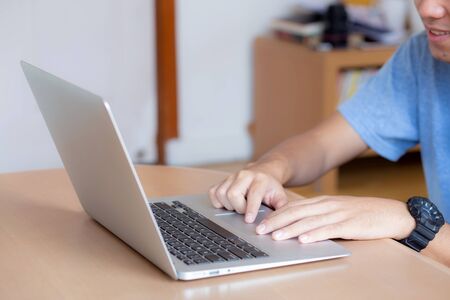 Closeup freelance asian man working and typing on laptop computer at desk office with professional,...