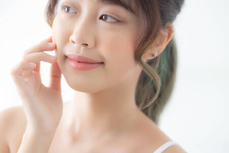 Portrait of beautiful young asian woman smile while wake up healthy and wellness with sunrise at morning in the bedroom, asia girl skin care with happy with fresh, lifestyle and relax concept.の写真素材