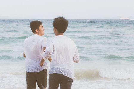 Homosexual portrait young asian couple running with cheerful together on beach in summerの写真素材