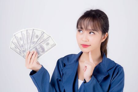 Beautiful young business asian woman holding money isolated on whiteの写真素材