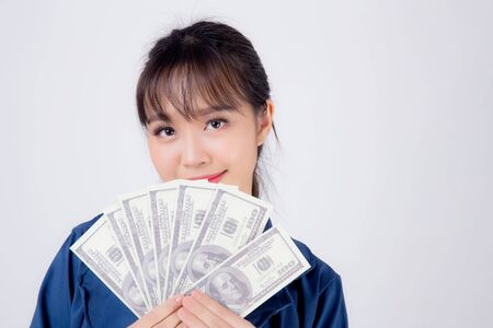 Beautiful portrait young business asian woman holding money isolated on white background, businesswoman showing banknotes with excited, happy girl income with profit finance and success concept.の写真素材