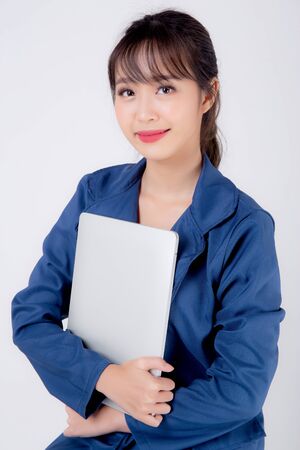 Beautiful portrait young asian business woman holding laptop computer isolated on white background, businesswoman using notebook, asia freelance girl work job surfing internet online or sending email.の写真素材