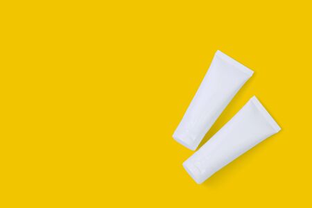 Cosmetic tube isolated on yellow background, mockup package of lotion or cream, product beauty and makeup, treatment skin care or acne, packaging or container, health and medicine template.の写真素材