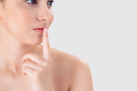 Beauty young asian woman gesture finger on mouth showing hush quiet and secret about skin care on face isolated on white background, beautiful of female with skincare for health on facial.の写真素材