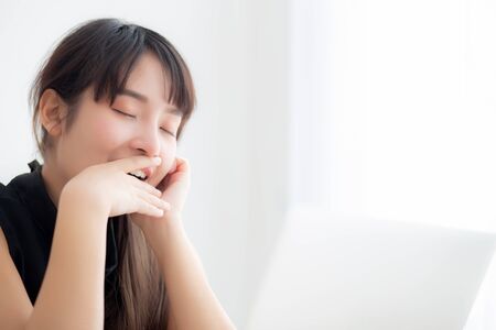 beautiful young freelance asian woman working bored and tired on laptop computer at the office, girl lazy sleepy and yawning on notebook, female secretary with exhausted, business concept.の写真素材