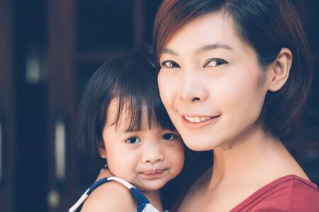 Family with portrait relationship of young asian mother and daughter cheerful and happy, mom and child smiling and hugging, expression emotion together, parent care kid, lifestyle concept.の写真素材