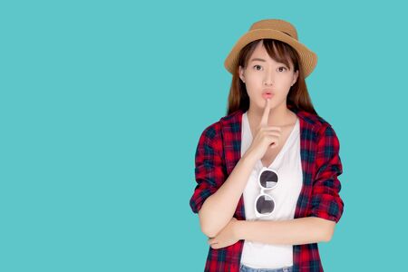 Beautiful portrait young asian woman wear hat having sunglasses confident and enjoy summer holiday isolated blue background, tourist model happy asia girl thinking idea planning travel concept.の写真素材