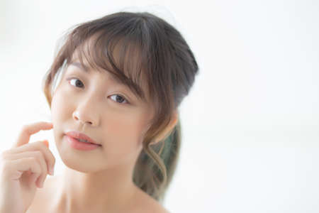 Portrait of beautiful young asian woman smile while wake up healthy and wellness with sunrise at morning in the bedroom, asia girl skin care with happy with fresh, lifestyle and relax concept.の写真素材