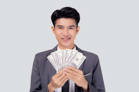 Young asian business man holding money dollar isolated on white background, businessman in suit holding banknote and success and excited with finance, savings and investment, income and spending.の写真素材