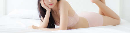 Beautiful young asian woman sexy in underwear figure fit relax in bedroom, asia girl body slim in lingerie confident and happy lying on bed in bedchamber, lifestyle concept, banner website.の写真素材