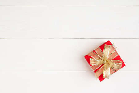 Red gift box on wooden table background, love and romance, presents in celebration and anniversary with surprise on desk, happy birthday, donate and charity, valentine day 14 February concept.の写真素材