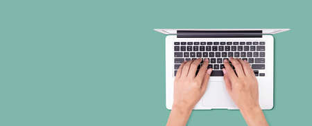 Businessman using laptop computer isolated on green background, business man typing keyboard on...