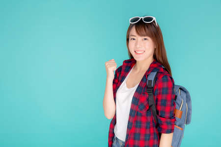 Beautiful portrait young asian woman wear sunglasses on head smile confident and excited summer holiday isolated blue background, model girl fashion having backpack, travel concept.の写真素材