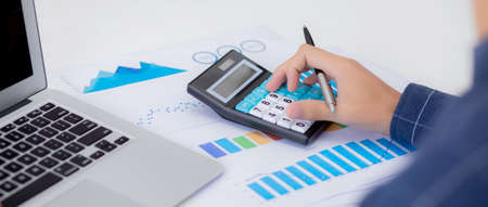 Hand of young asian business man working using calculator for planning accountant, graph for finance...