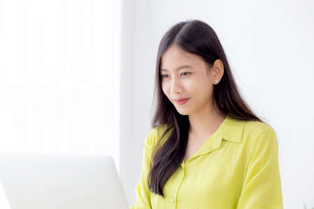 Young asian businesswoman working on laptop computer on desk at home office, freelance looking and...
