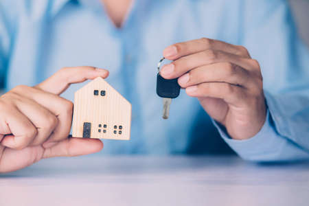 Hand of businessman is agent holding key house, insurance home and real estate for investment,...
