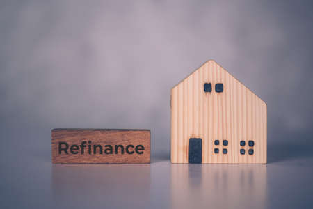 Wooden block with refinance word and house model about home and finance, loan and mortgage for real estate and property, residential and planning with budget, investment and earning, business concept.の写真素材