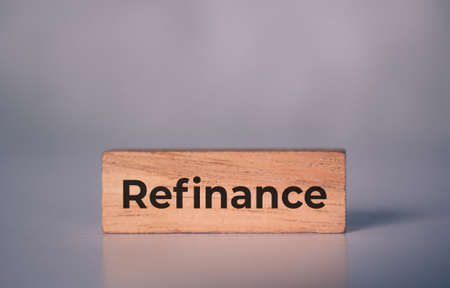 Wooden block with refinance word about home and finance, loan and mortgage for real estate and property, residential and planning with budget, nobody, investment and earning, business concept.の写真素材