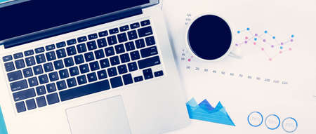 Laptop computer and documents report statistic financial with graph and chart and coffee on desk,...
