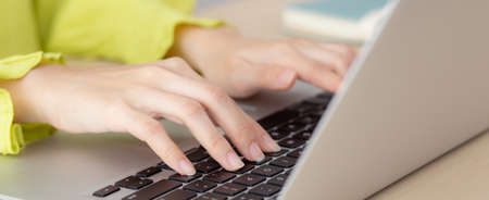 Closeup of hand young asian businesswoman working on laptop computer on desk at home office,...