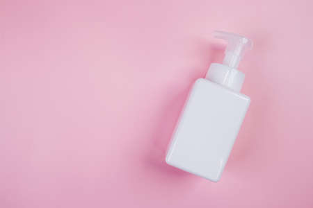 Mockup cosmetic bottle with cream or lotion isolated on pink background, mock up package for advertising, skincare or cosmetology, top view, flat lay, skin care and treatment with product.の写真素材