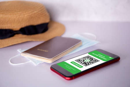 Vaccine passport, health vaccinated on app with mobile smart phone on desk, vaccination for immune with travel, certificate for safety of tourist, scan signing for smartphone for tourism.の写真素材
