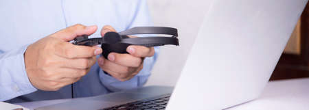 Hands of man holding headphone while laptop computer on desk, e-learning online, webinar for...